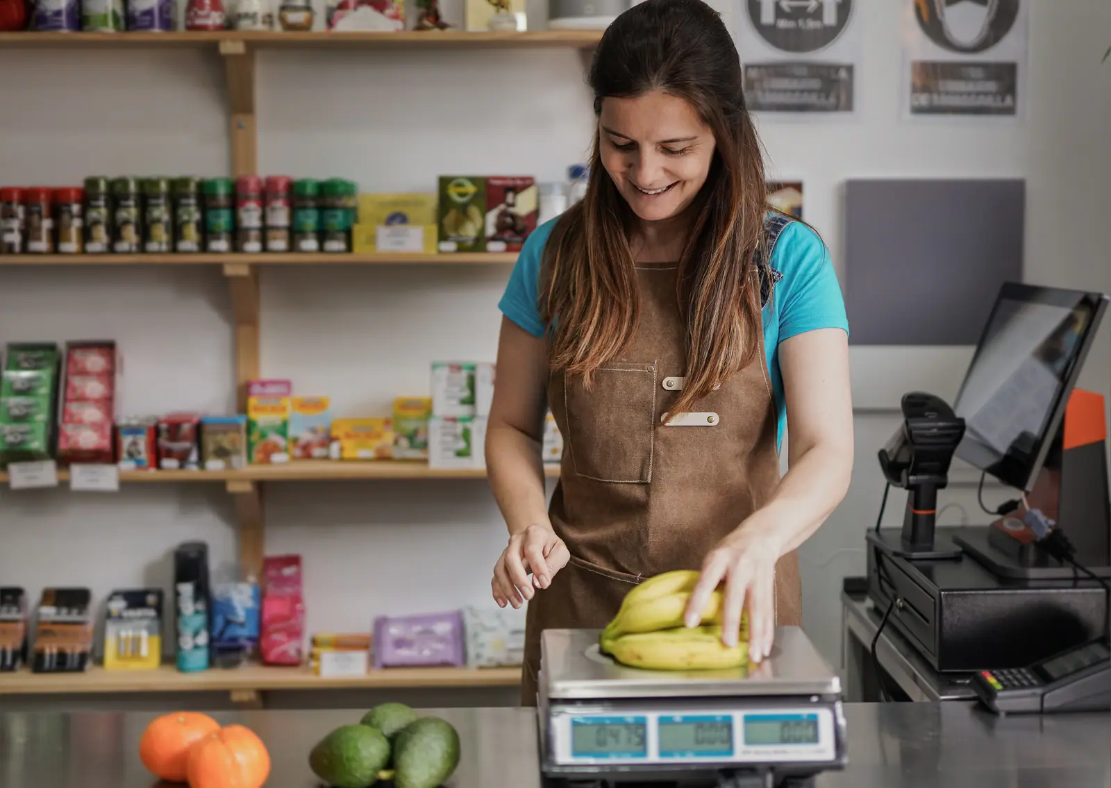 Comerciante pesando frutas en báscula conectada al TPV — software para alimentación con Beply